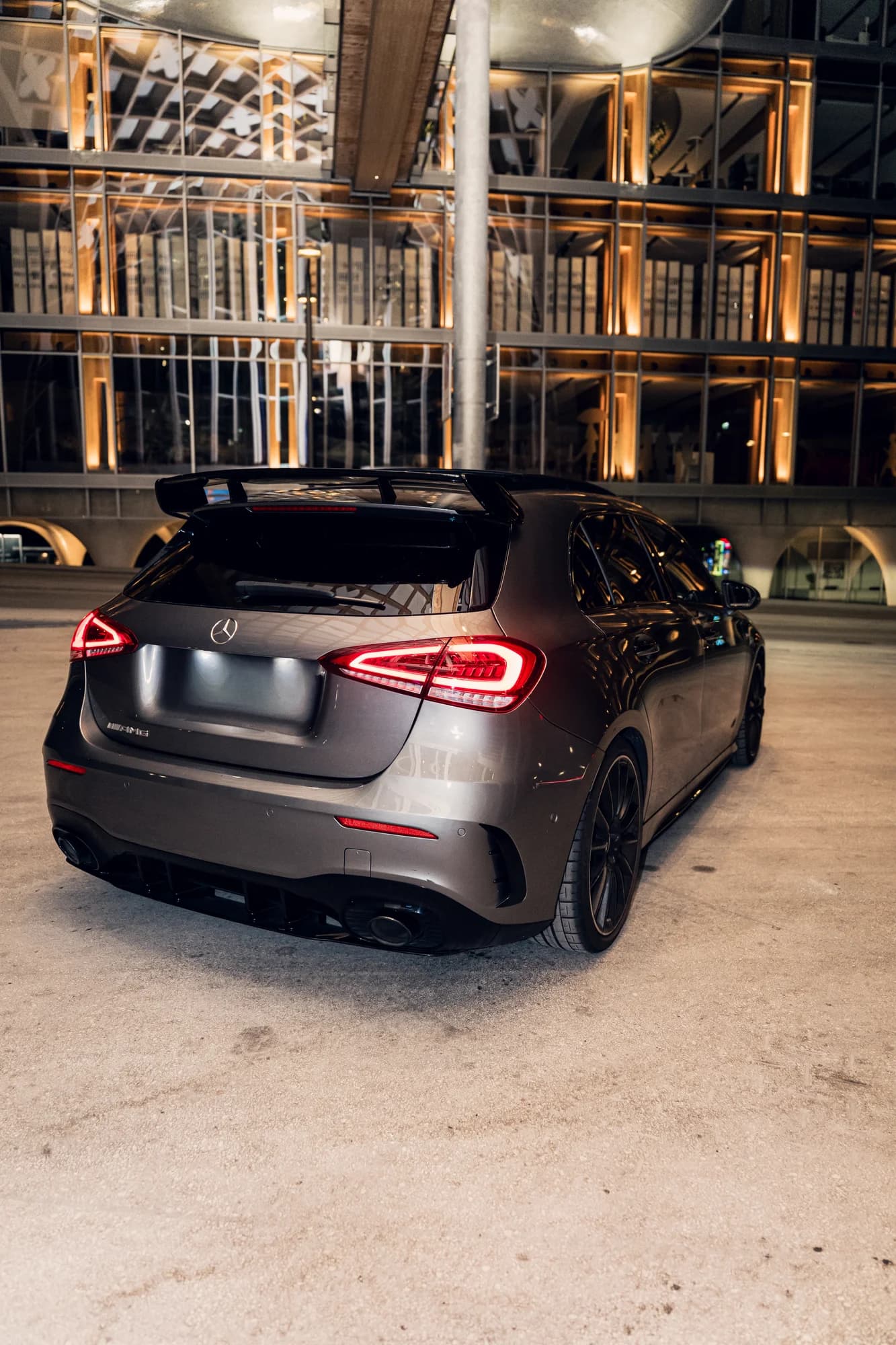 Arrière de la Mercedes-AMG A35 devant une façade illuminée