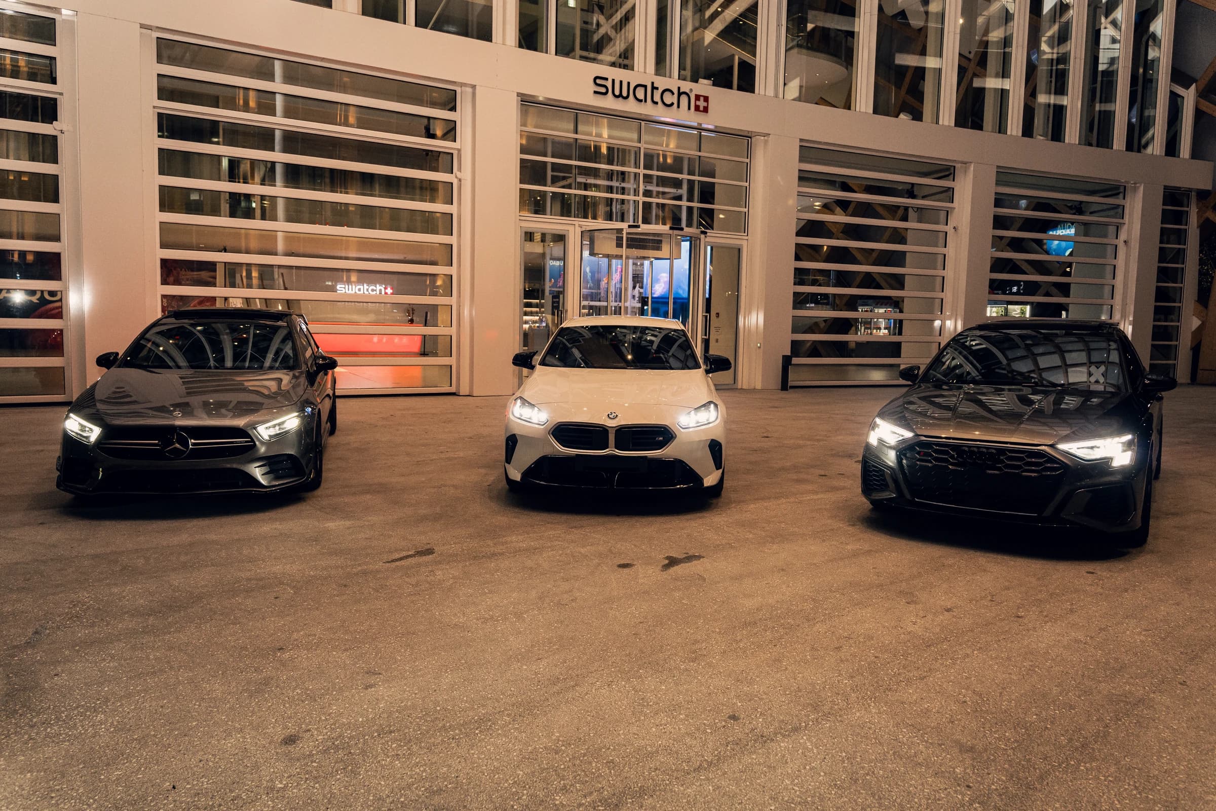Mercedes-AMG A35, BMW M135 et Audi S3 ABT réunies devant le bâtiment Swatch
